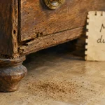 Mites bois meuble : petits trous et vermoulure sur commode en bois